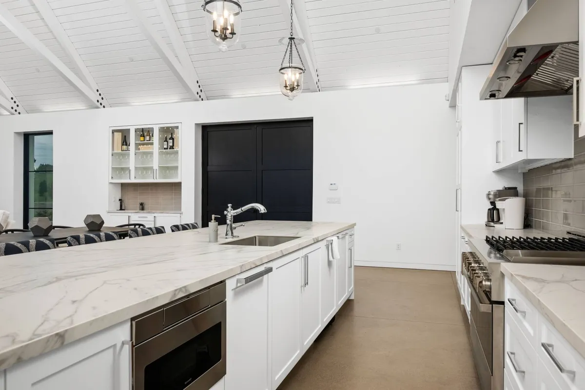 A modern kitchen featuring a large island, stylish pendant lighting, and top-of-the-line appliances. The open layout invites culinary creativity and social interaction, making it ideal for both cooking and entertaining. The kitchen’s design is sleek, functional, and welcoming.